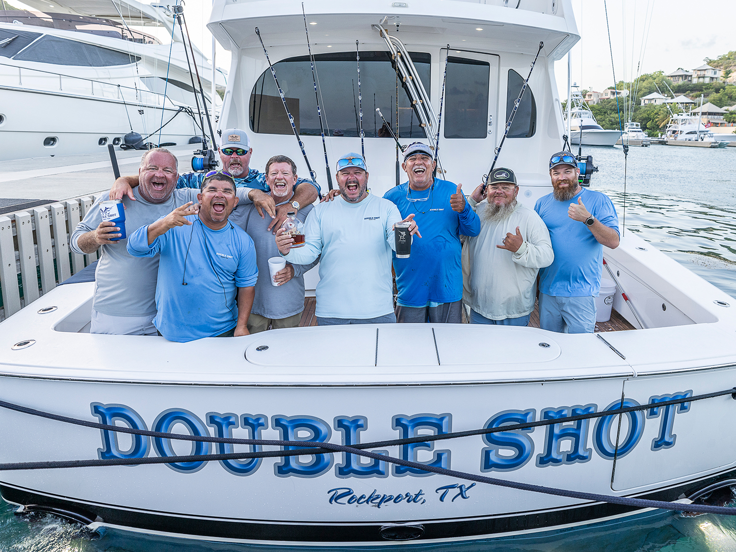 A sport-fishing team celebrates a win on the deck of their sport-fishing boat.